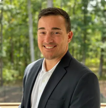 A headshot of Geoff Spillias, founder and CEO dressed of Fenix Recovery, in a suit, smiling at the camera.